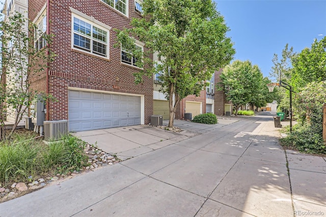 3411 N Xenia St, Denver, CO 80238 - view of front facade featuring brick siding, driveway, and a garage