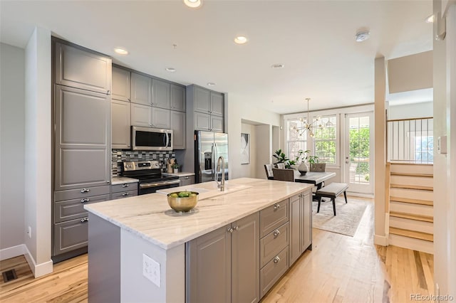 3411 N Xenia St, Denver, CO 80238 - kitchen with stainless steel appliances, gray cabinets, light wood finished floors, light stone counters, and recessed lighting