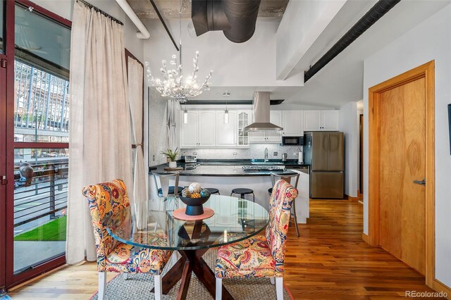 dining room featuring a notable chandelier, sink, and light hardwood / wood-style floors