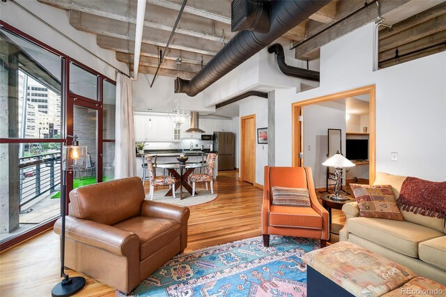 living room with beamed ceiling, hardwood / wood-style floors, and a towering ceiling