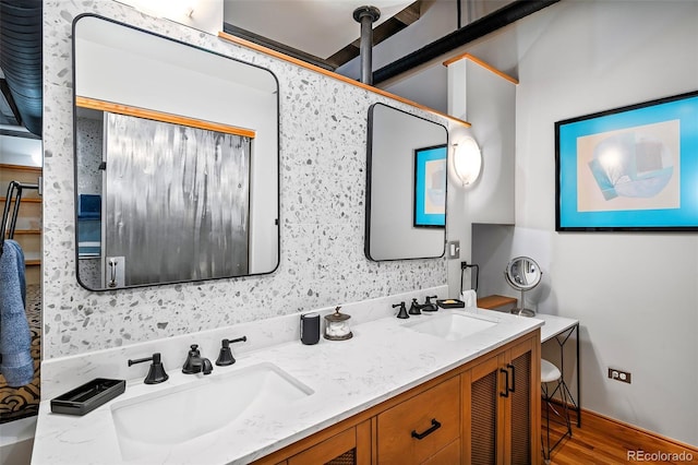 bathroom with wood finished floors, a sink, and double vanity