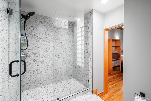 bathroom featuring wood-type flooring and an enclosed shower