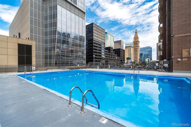 pool featuring a view of city and fence