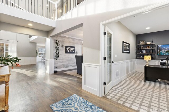 interior space featuring a wainscoted wall, visible vents, and wood finished floors