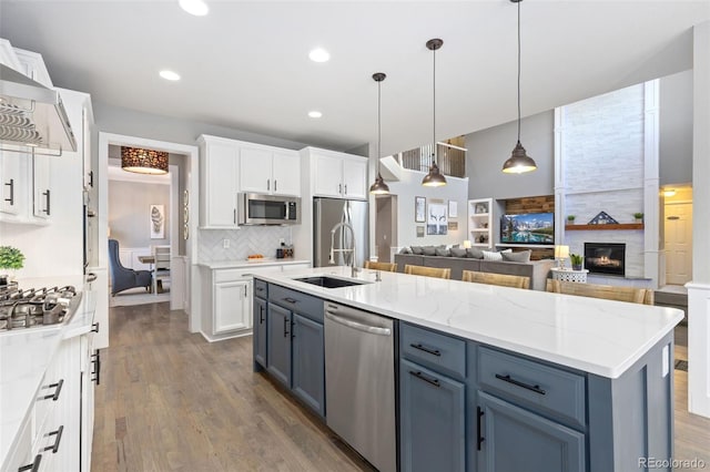 kitchen with open floor plan, stainless steel appliances, dark wood-style flooring, and white cabinetry