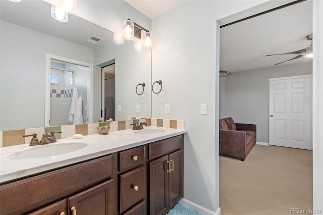 full bathroom featuring ceiling fan, double vanity, a sink, and baseboards