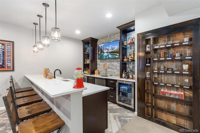 bar with dishwasher, wine cooler, decorative light fixtures, wet bar, and a sink