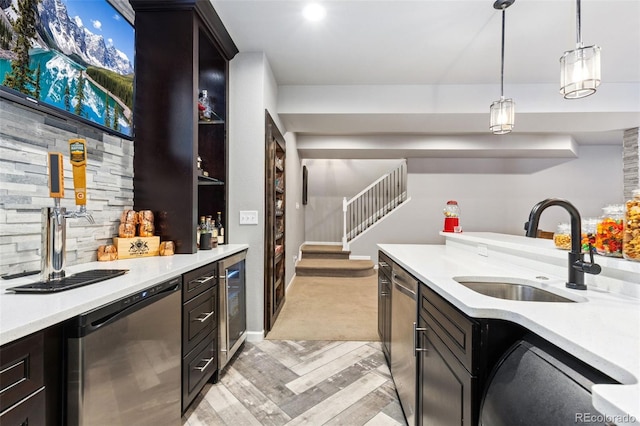 kitchen with wine cooler, a sink, light countertops, hanging light fixtures, and dishwasher