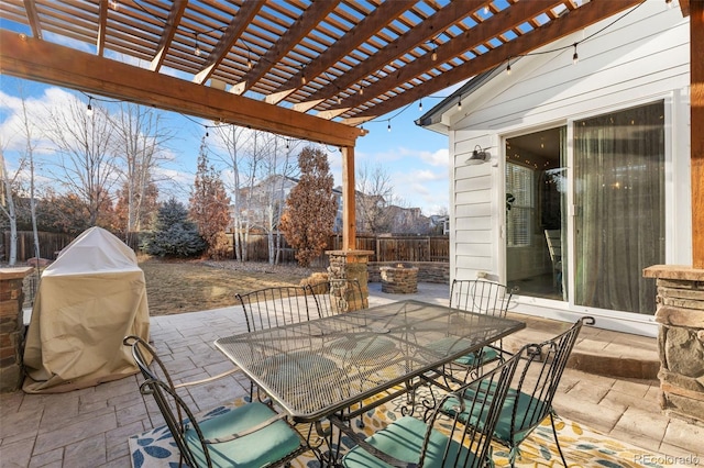 view of patio featuring a fire pit, outdoor dining area, area for grilling, and a fenced backyard