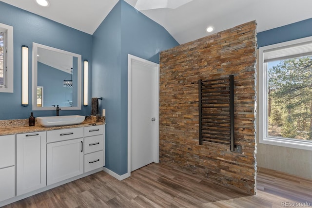 bathroom featuring lofted ceiling, vanity, and hardwood / wood-style floors