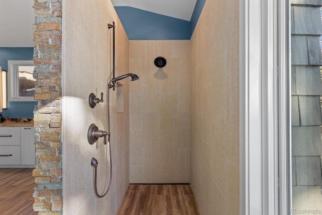 bathroom featuring vaulted ceiling, walk in shower, and hardwood / wood-style floors