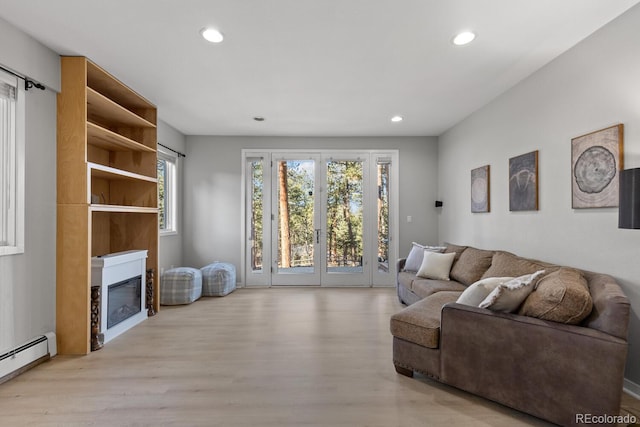 living room featuring light hardwood / wood-style floors and a baseboard heating unit