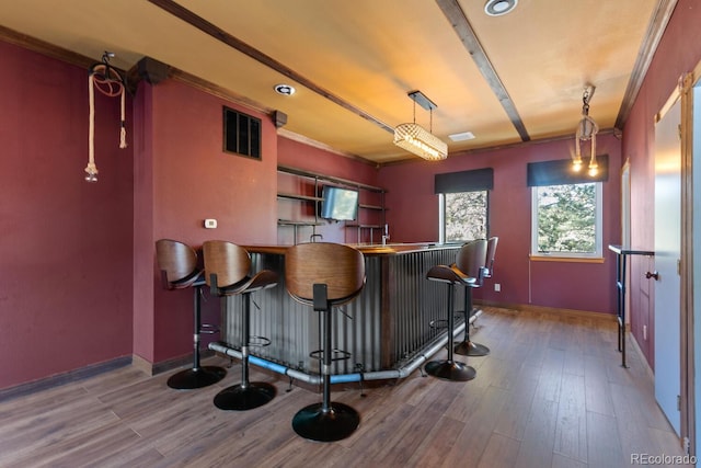 bar featuring decorative light fixtures, hardwood / wood-style flooring, and crown molding