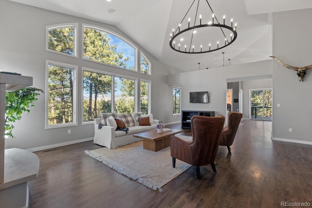 living room with a notable chandelier, a towering ceiling, and dark hardwood / wood-style floors