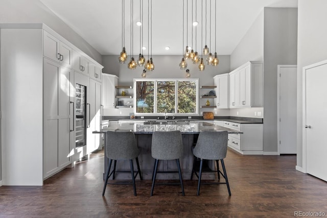 kitchen with a kitchen island, decorative light fixtures, a kitchen breakfast bar, and white cabinets