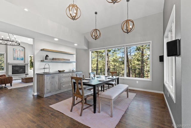 dining area with a high ceiling, dark wood-type flooring, and sink