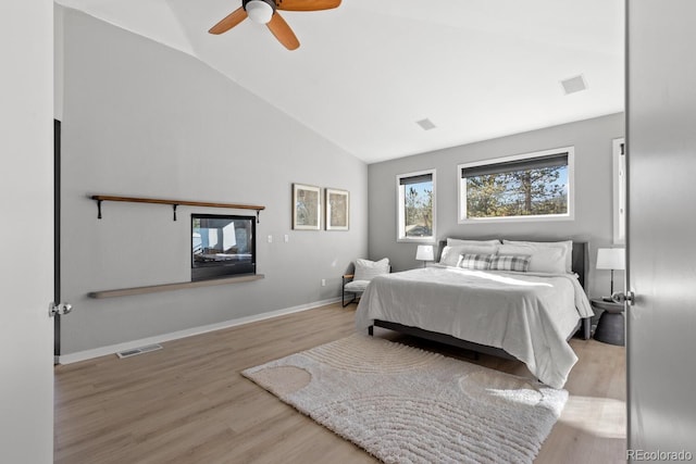 bedroom featuring ceiling fan, light wood-type flooring, and vaulted ceiling