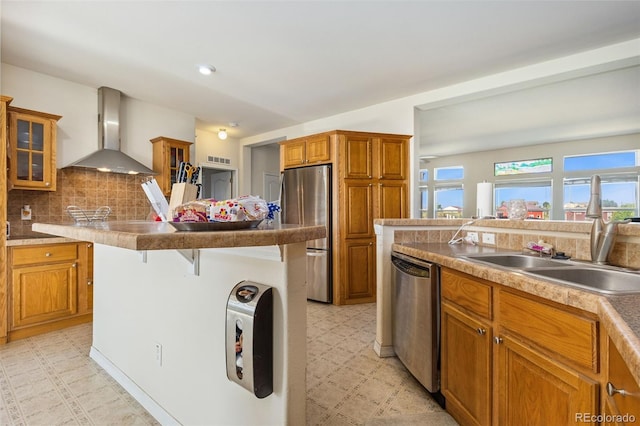 4241 Meadowlark Rd, Fort Lupton, CO 80621 - kitchen featuring wall chimney exhaust hood, appliances with stainless steel finishes, light flooring, a kitchen breakfast bar, and brown cabinetry