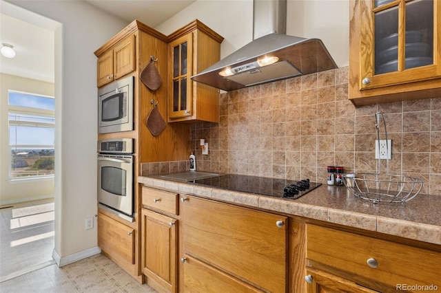 4241 Meadowlark Rd, Fort Lupton, CO 80621 - kitchen with wall chimney range hood, appliances with stainless steel finishes, brown cabinetry, and decorative backsplash