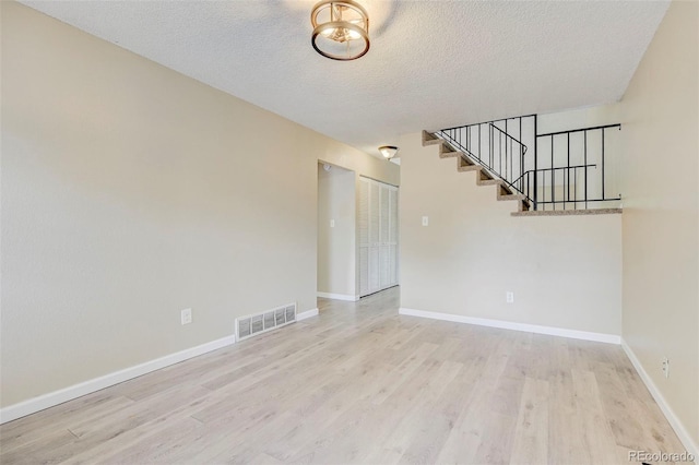 2726 Dickens Dr, Colorado Springs, CO 80916 - spare room with wood finished floors, stairs, a textured ceiling, and baseboards
