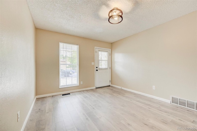 2726 Dickens Dr, Colorado Springs, CO 80916 - foyer entrance featuring light wood finished floors, a textured ceiling, and baseboards