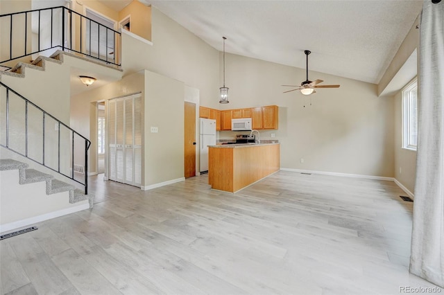2726 Dickens Dr, Colorado Springs, CO 80916 - kitchen with white appliances, open floor plan, ceiling fan, a peninsula, and light wood-style flooring