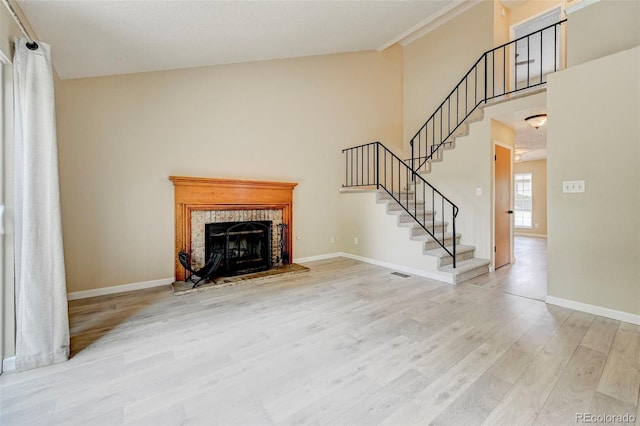 2726 Dickens Dr, Colorado Springs, CO 80916 - unfurnished living room featuring wood finished floors, baseboards, stairs, a fireplace, and high vaulted ceiling