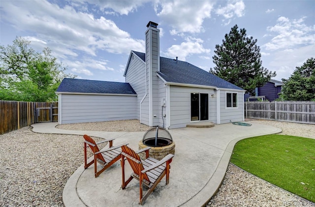 2726 Dickens Dr, Colorado Springs, CO 80916 - rear view of house with a fire pit, a patio, a fenced backyard, a chimney, and roof with shingles