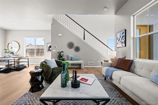 20871 E 60th Ave, Aurora, CO 80019 - living area featuring stairway, wood finished floors, and baseboards