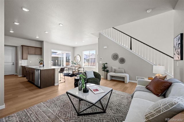 20871 E 60th Ave, Aurora, CO 80019 - living area featuring stairway, light wood-style floors, recessed lighting, and baseboards