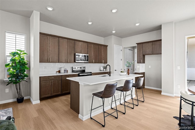 20871 E 60th Ave, Aurora, CO 80019 - kitchen with stainless steel appliances, a sink, light wood-style flooring, dark brown cabinets, and recessed lighting