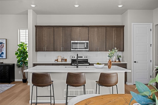 20871 E 60th Ave, Aurora, CO 80019 - kitchen with appliances with stainless steel finishes, decorative backsplash, dark brown cabinets, light countertops, and recessed lighting