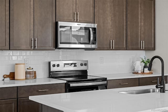 20871 E 60th Ave, Aurora, CO 80019 - kitchen featuring stainless steel appliances, dark brown cabinetry, a sink, and light countertops
