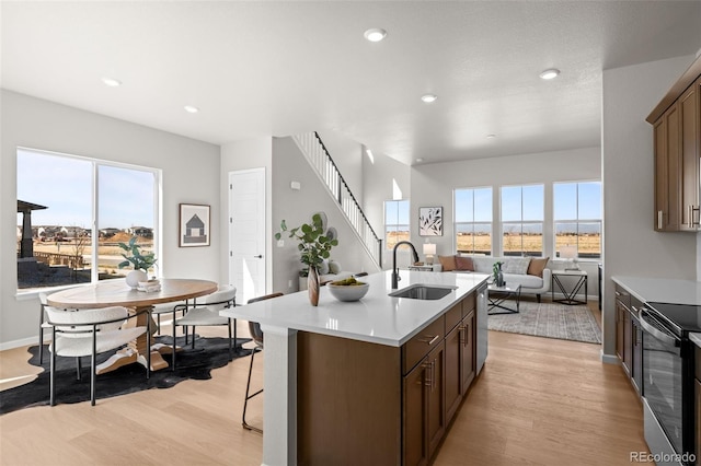 20871 E 60th Ave, Aurora, CO 80019 - kitchen with a sink, stainless steel appliances, light wood-type flooring, light countertops, and a breakfast bar