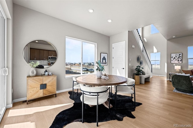 20871 E 60th Ave, Aurora, CO 80019 - dining room featuring light wood-type flooring, plenty of natural light, baseboards, stairs, and recessed lighting