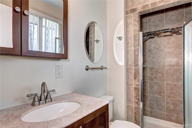 full bath featuring vanity, toilet, and a tile shower