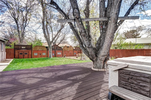 deck with a yard, fence, and an outdoor structure