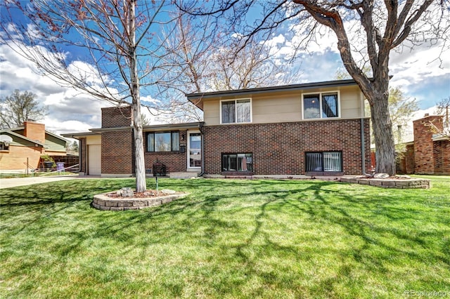 rear view of property featuring a yard, concrete driveway, a garage, and brick siding