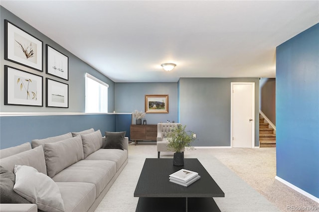 living room with light carpet, stairs, and baseboards