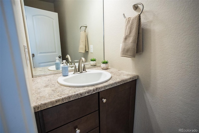 bathroom featuring vanity and a textured wall