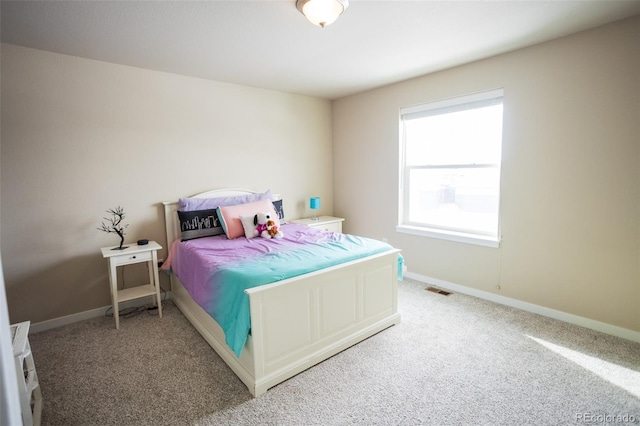 bedroom with visible vents, light colored carpet, and baseboards