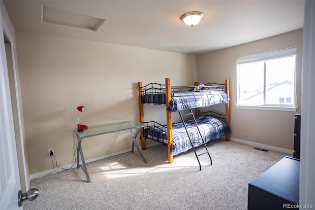 bedroom featuring baseboards, visible vents, attic access, and carpet