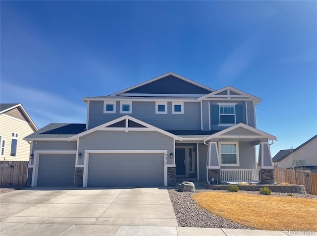 craftsman inspired home featuring a porch, concrete driveway, fence, and stone siding