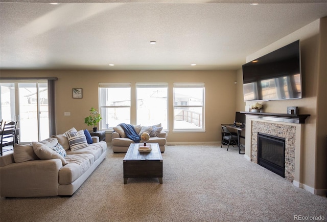 living area with baseboards, carpet floors, recessed lighting, a textured ceiling, and a glass covered fireplace