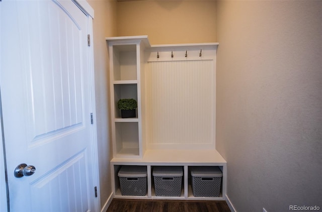 mudroom with dark wood finished floors and baseboards