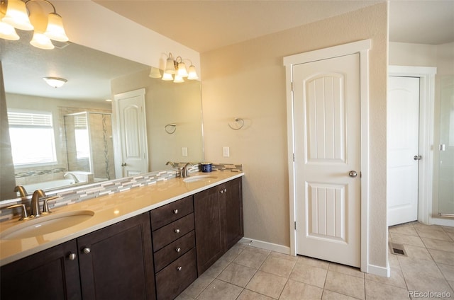 full bathroom with a sink, double vanity, a shower stall, and tile patterned flooring