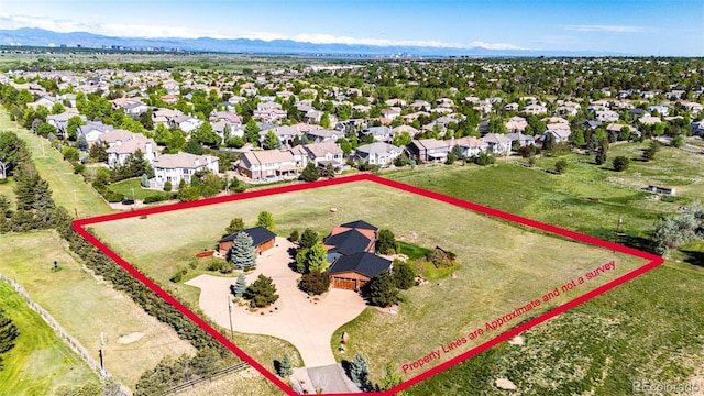 aerial view of residential area with property parcel outlined and a mountain backdrop
