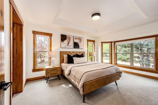 bedroom with baseboards, light carpet, and multiple windows