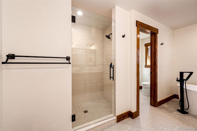 bathroom featuring a stall shower, a freestanding bath, toilet, baseboards, and tile patterned flooring