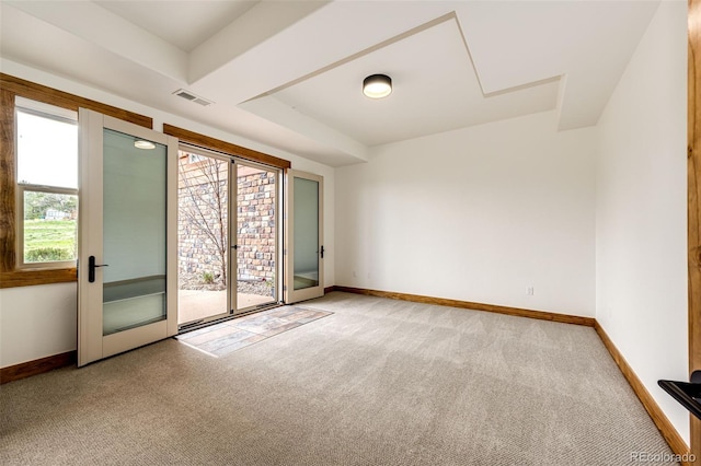 spare room featuring light colored carpet and baseboards